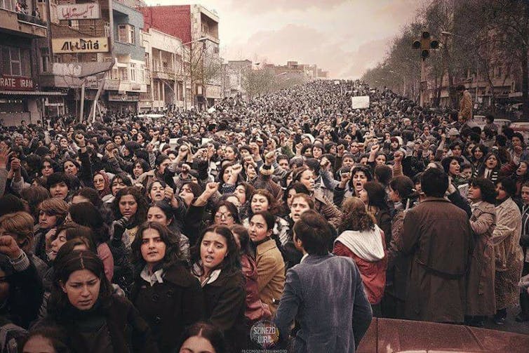 A large group of women march down a street.