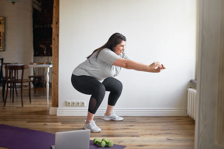 A woman does squats at home.