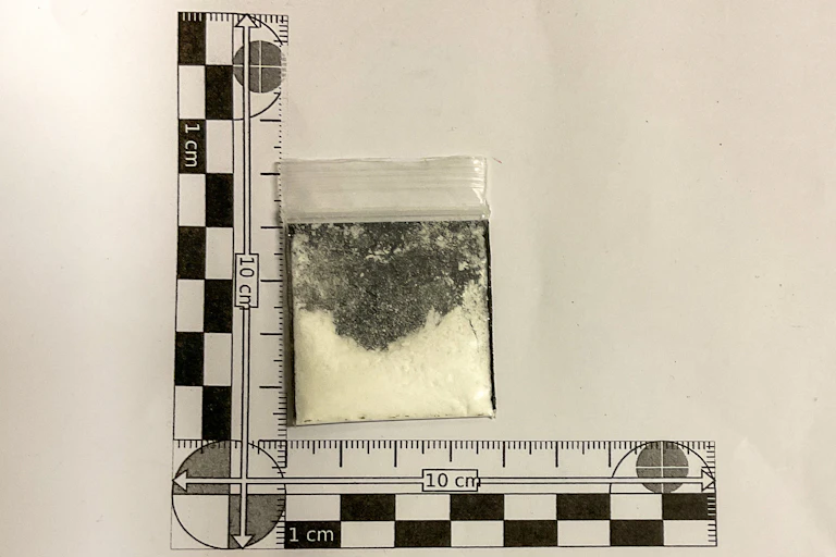 A plastic bag with a white powder in it with scale measure next to it