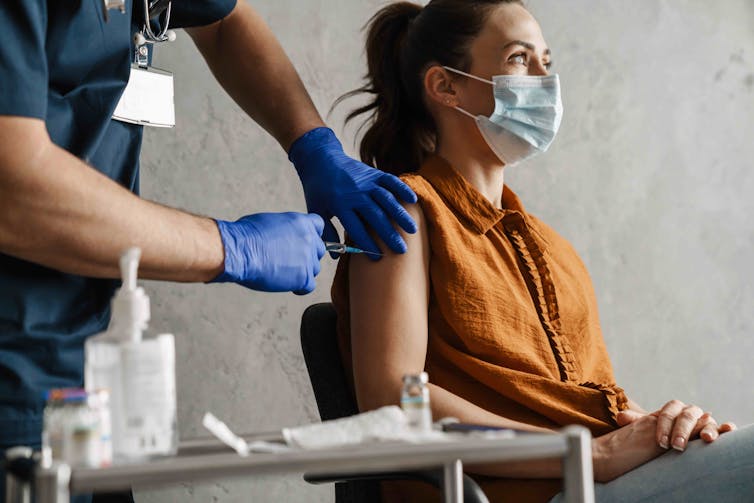 A woman receives a vaccination.