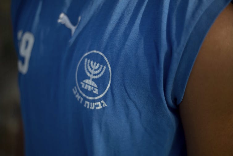 A blue football shirt featuring a club emblem and the logo for Puma.