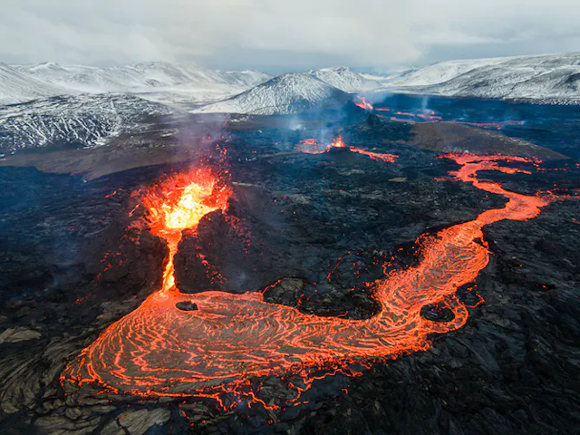 Sungai lava berwarna jingga cerah mengalir dari gunung berapi yang meletus