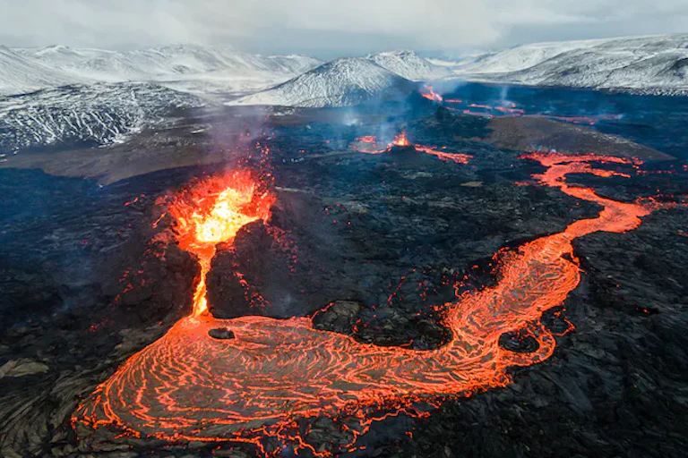 Sungai lava berwarna jingga cerah mengalir dari gunung berapi yang meletus