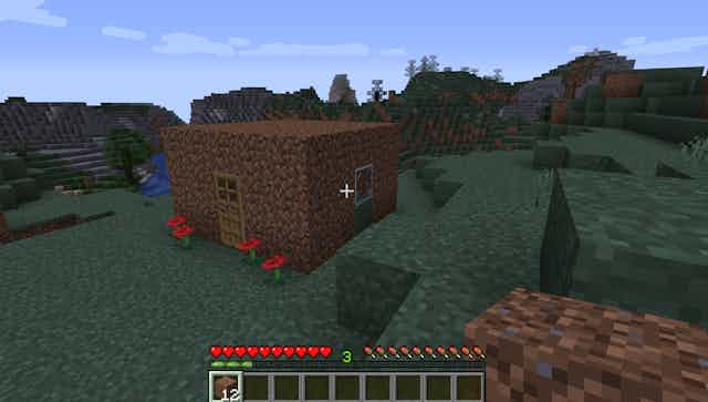 A still from the game Minecraft shows a small brick hut 