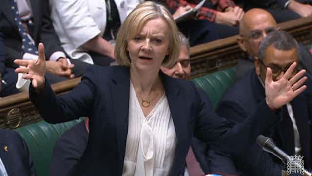 Liz Truss holds up her hands in parliament.