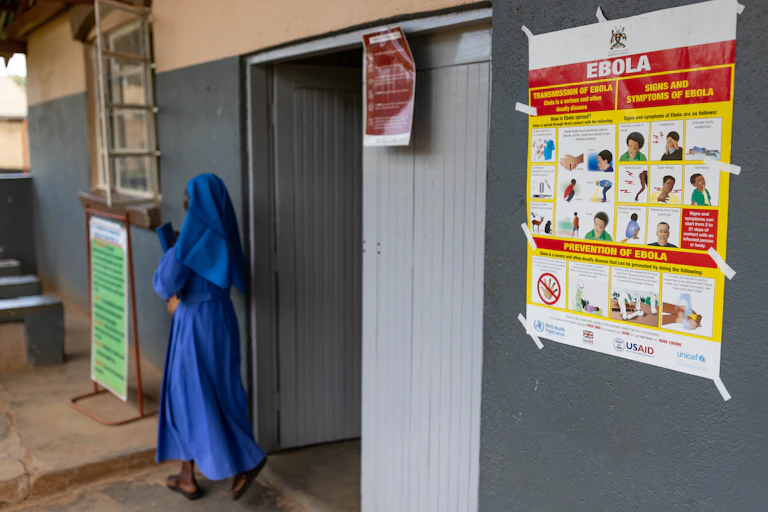woman walking past Ebola signage