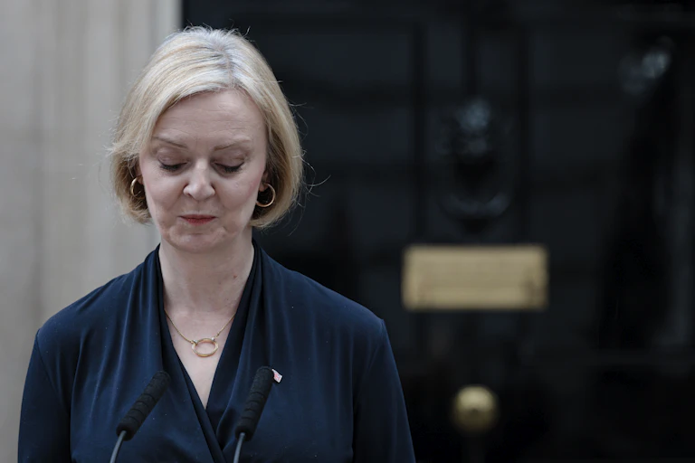 A woman with blond hair looks downcast in front of a door with '10' on it.