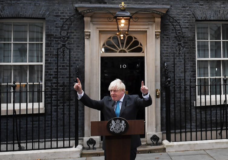 Boris Johnson pointing in the air with both hands while giving his resignation speech outside of Downing Street