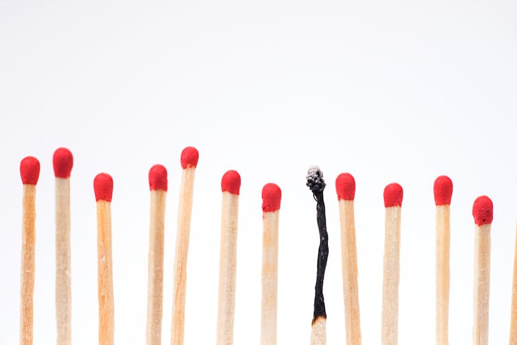 A row of matches with red tips, with one burnt up match