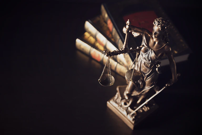 small stature of lady justice in front of law books