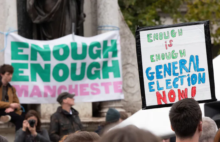 A protestor holding a sign reading