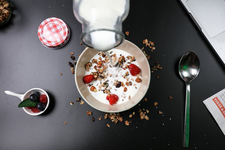 Milk is poured into a bowl of cereal.