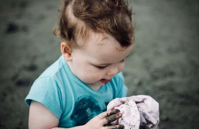 A small child playing in the dirt.