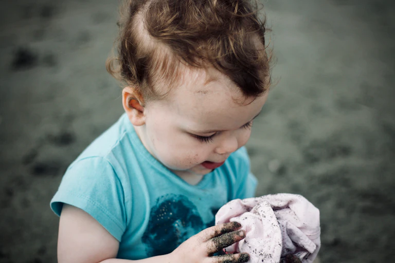 A small child playing in the dirt.