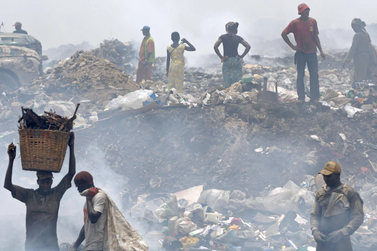 Men, women working at a dump site.