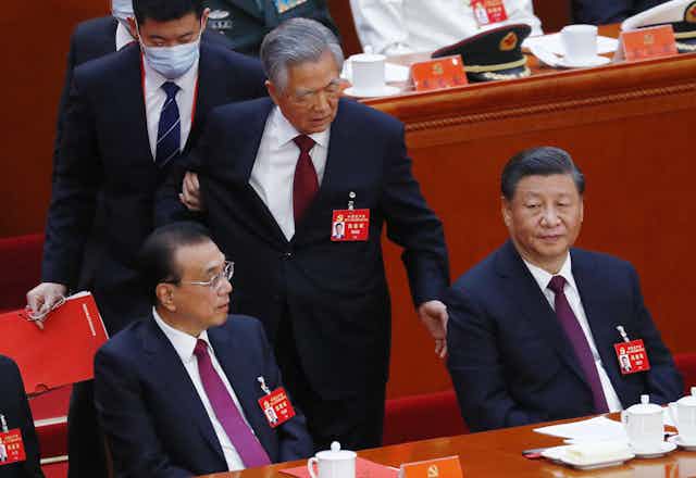 China's former President Hu Jintao (C) is led out by a steward as President Xi Jinping (R) and Premier Li Keqiang (L) look on during the closing ceremony of the 20th National Congress of the Communist Party of China (CPC) at the Great Hall of People in Beijing, China, 22 October 2022. 