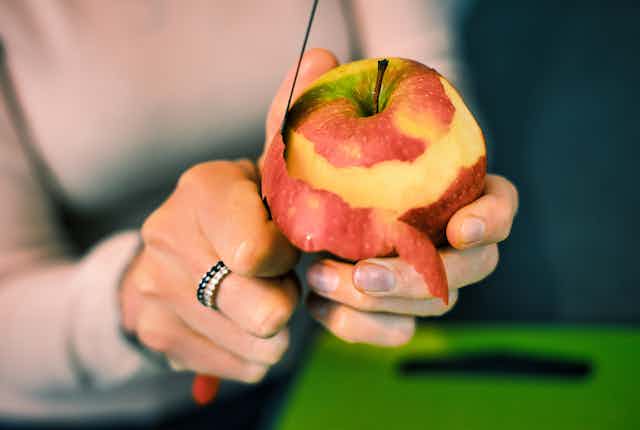 Person peeling an apple