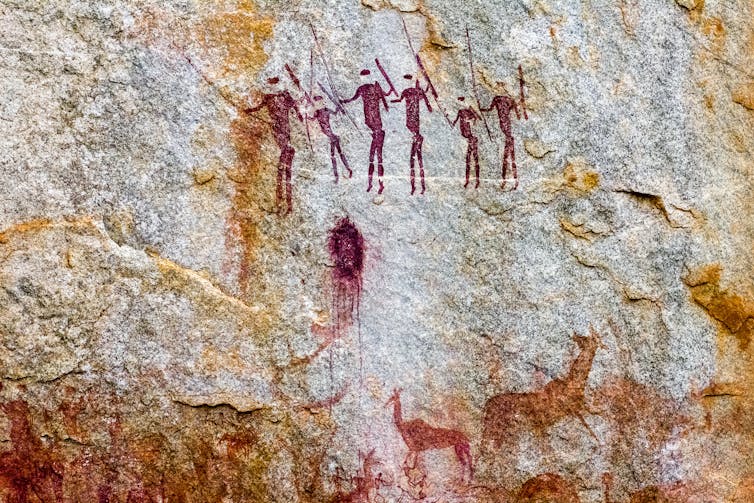 illustration of primitive red figures on a rock background