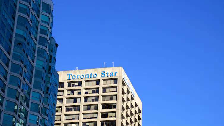 The top of a beige building with Toronto Star written on the top in blue lettering.