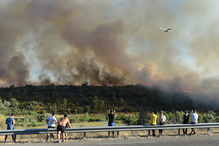 Personnes regardant un incendie sur le haut d'une colline