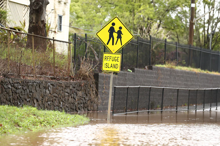 street sign with two figures reads 'refuge island' footpath is flooded