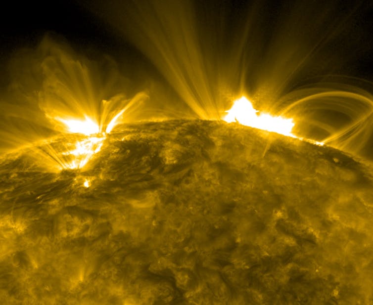 A photograph of solar flares emanating from the Sun.