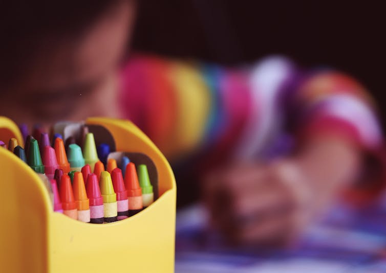 Child draws with crayons