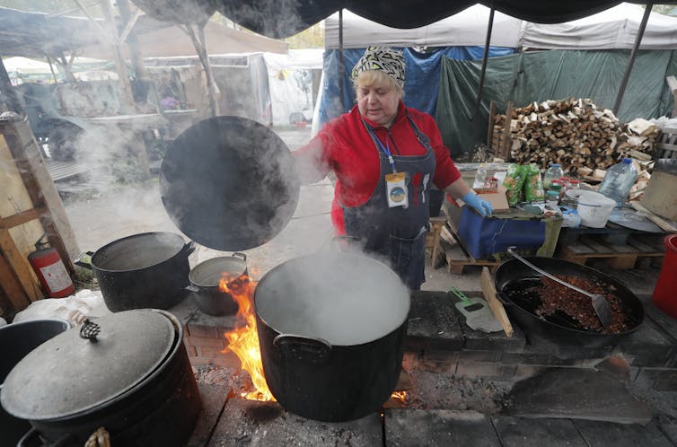 A volunteer cooks hot food which they distribute to Ukrainians in Kyiv, Ukraine, 21 October 2022.