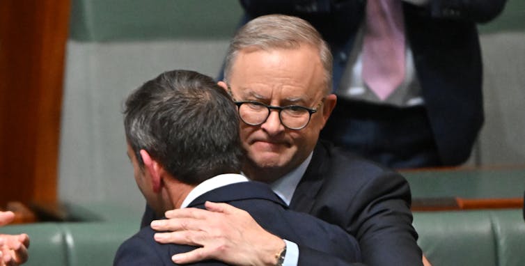 Australia's Treasurer Jim Chalmers and Prime Minister Anthony Albanese hug after Chalmers delivers his first budget speech in parliament, October 25 2022.