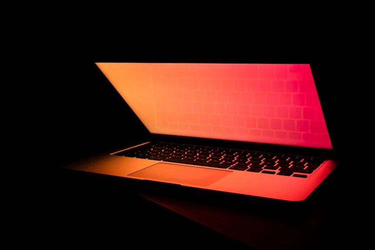 Laptop bathed in orange and red light