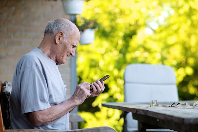 Older man looks at phone