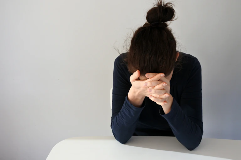 Woman holding her head, looking exhausted