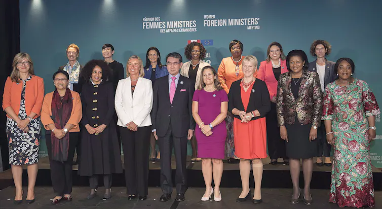 Un groupe d’hommes et de femmes posent pour une photo