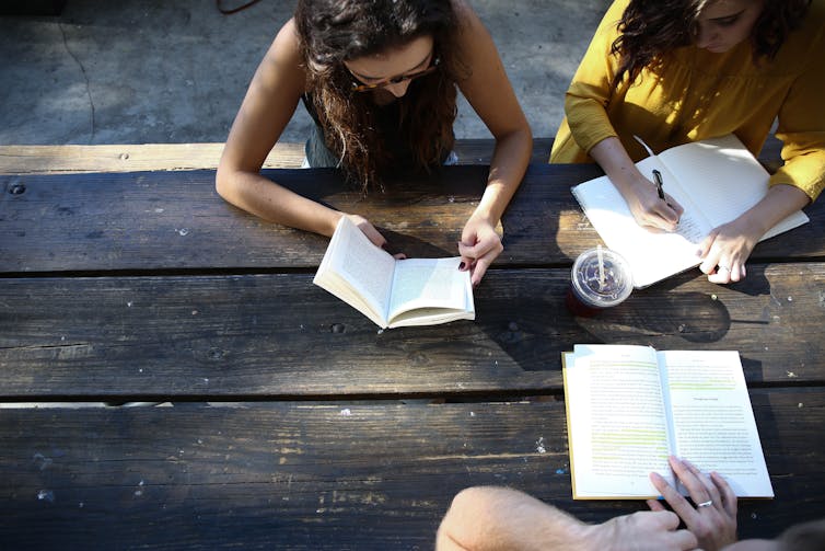 Students reading at a bench.