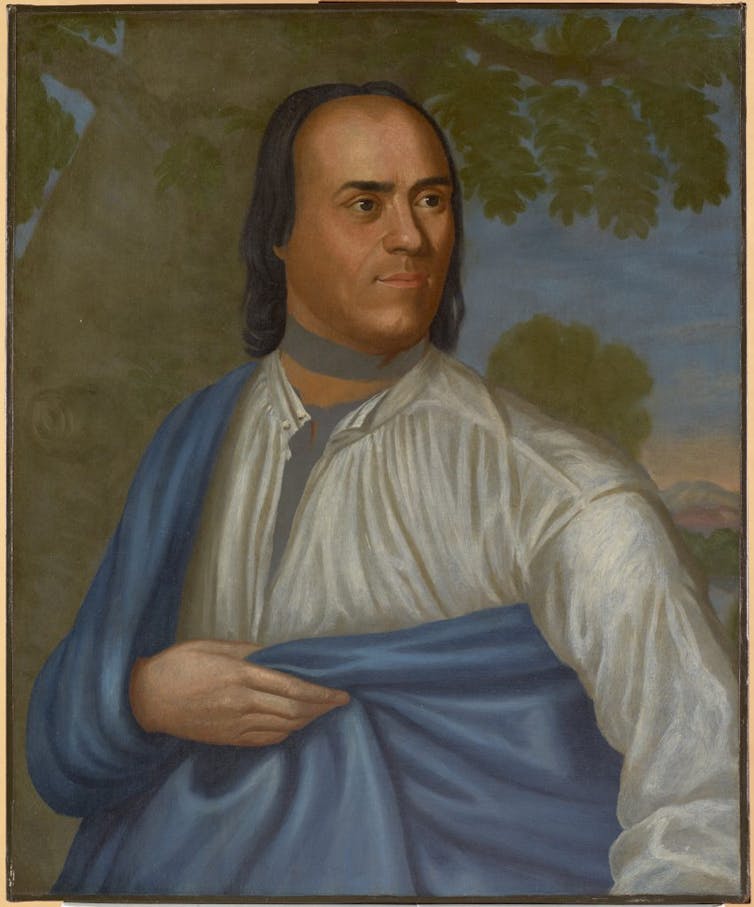 Painting of a Native American man in a drapey shirt and cape looking to the right. Trees and sky are in the background.