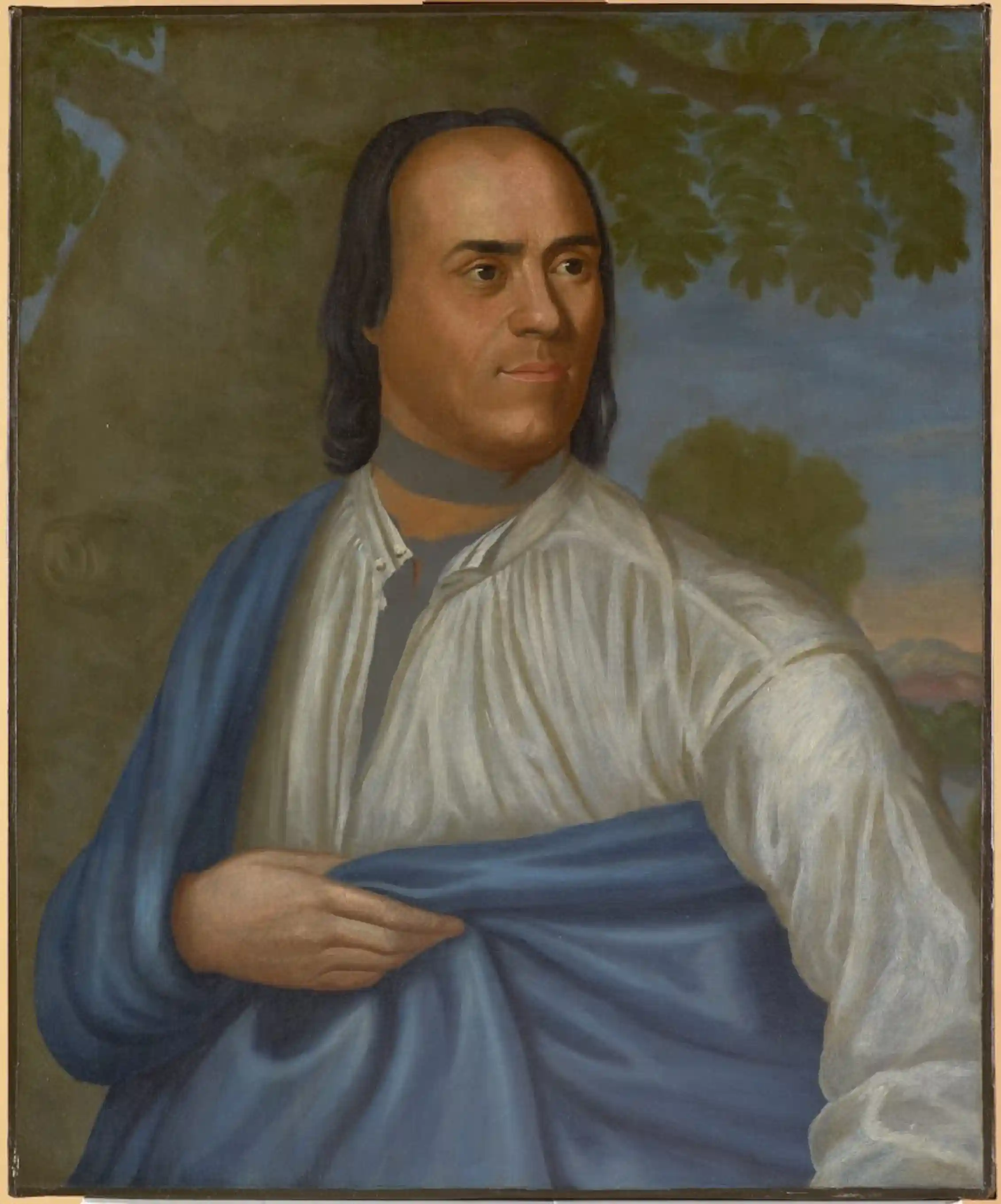 Painting of a Native American man in a drapey shirt and cape looking to the right. Trees and sky are in the background.
