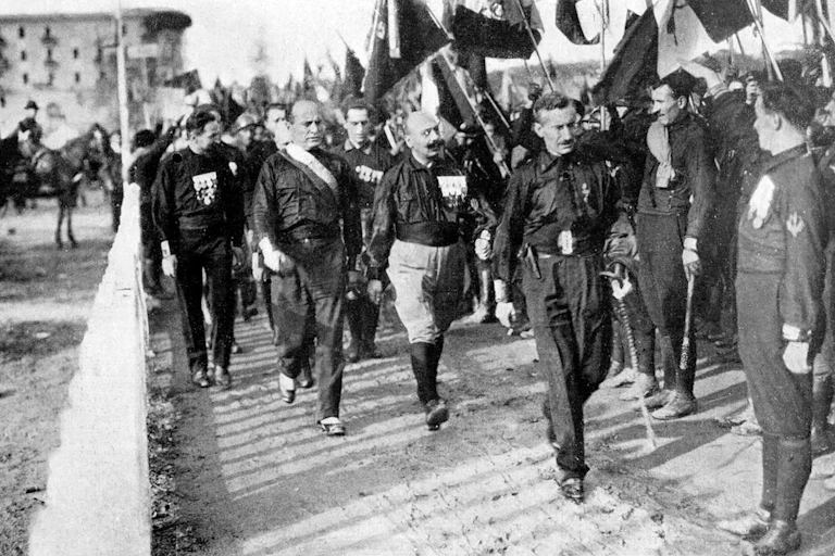 Mussolini and black shirt fascists marching with Italian flags.