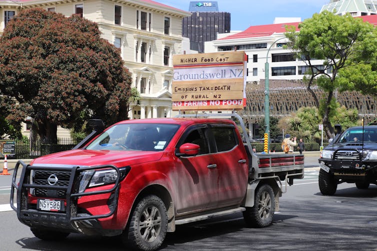 Red truck carrying protest signs against proposed methane tax