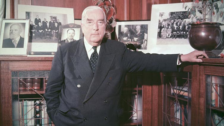 Robert Menzies posing in front of a bookcase.
