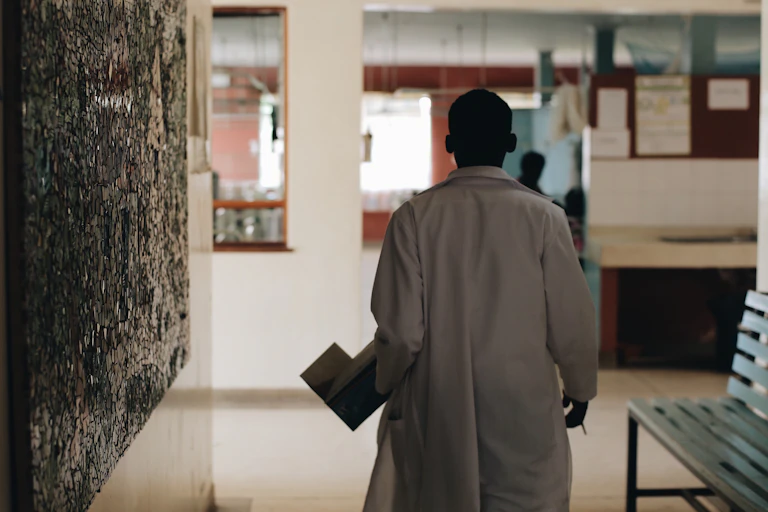 Doctor walks towards nurses' desk