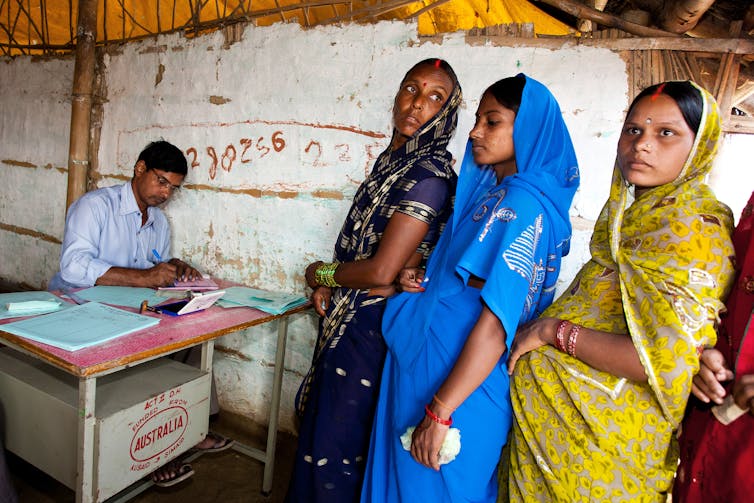 Indian women stand in line at a pregnancy clinic