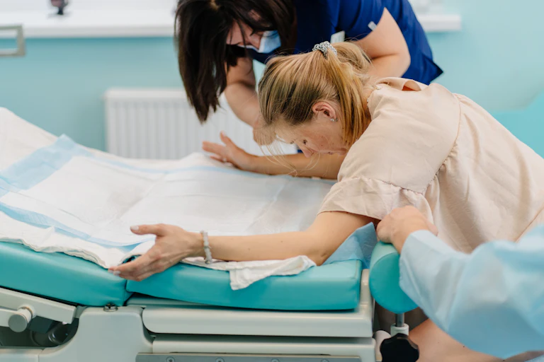Nurse and doctor talk to woman labouring with contractions