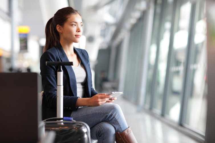 Career woman looking out an airport window thoughtfully