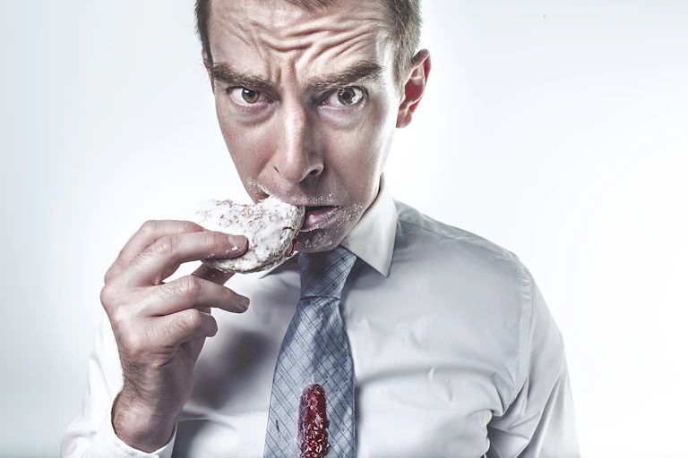 Homme qui mange un biscuit en culpabilisant