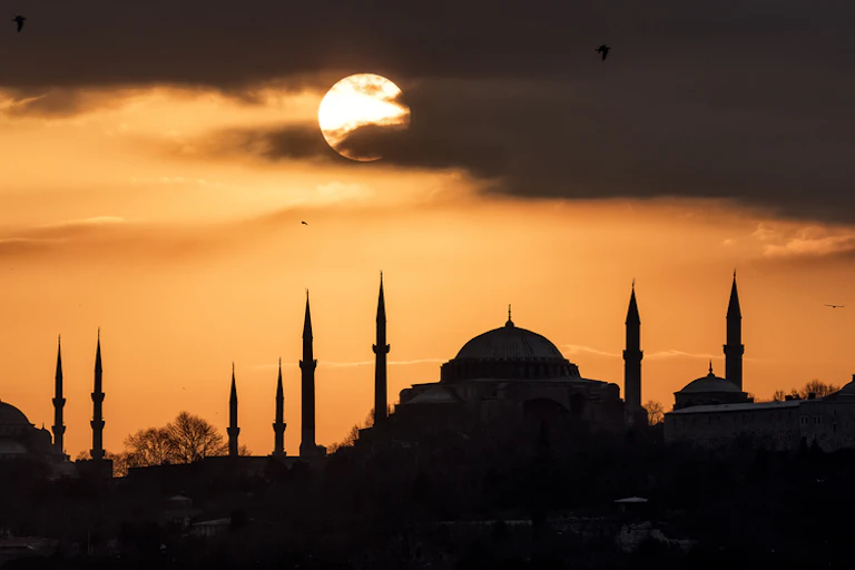 Sunset over silhouetted buildings.