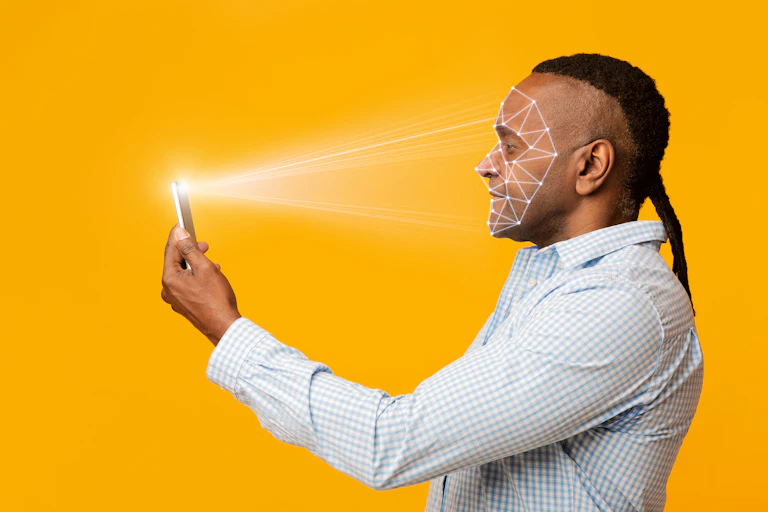 A Black man scanning his face with a phone.