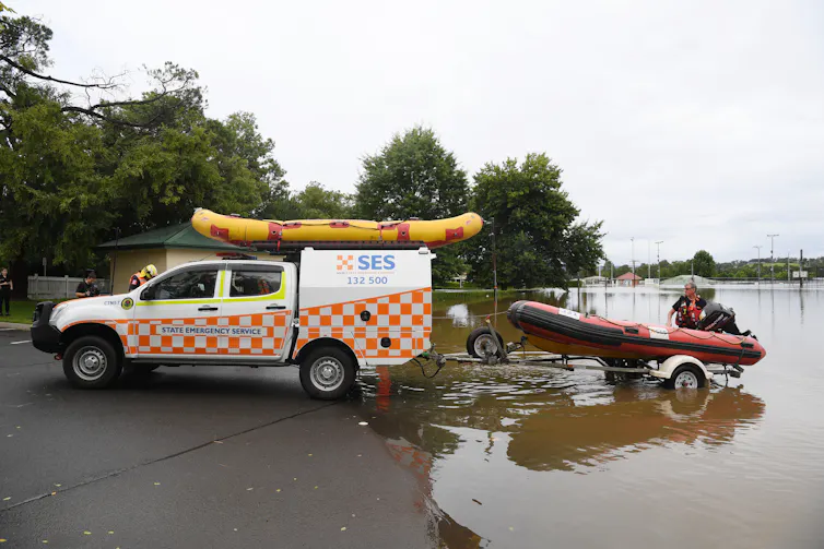 SES car pulls an inflatable boat out of a flooded street