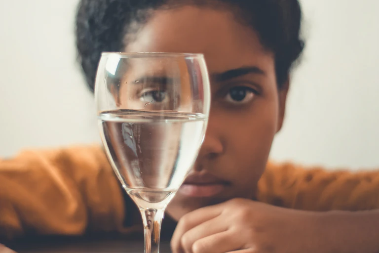 girl stares into glass of water