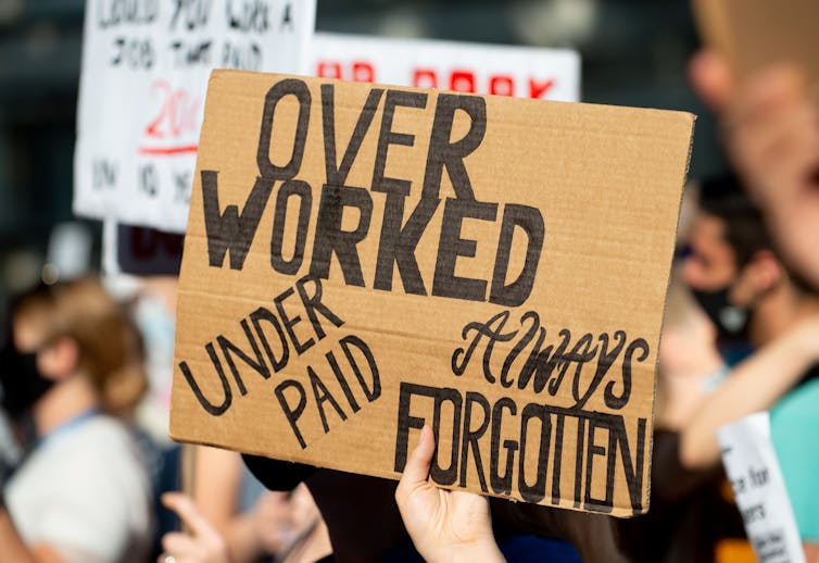 A cardboard sign held up at a strike says: