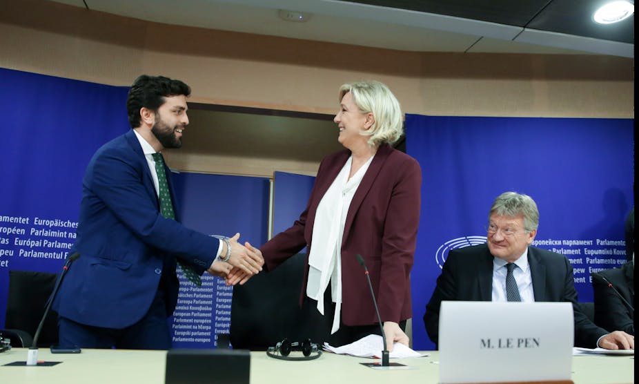 Marco Zanni of Lega shakes hands with the RN's Marine Le Pen in Brussels in 2013.